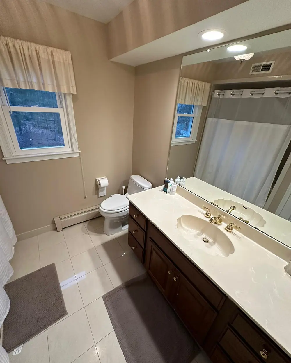 Freshly cleaned bathroom with bright tile and glass surfaces
