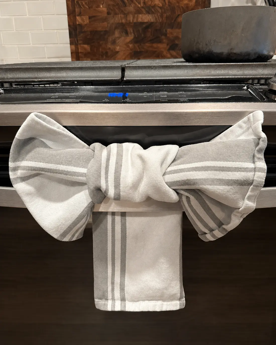Striped kitchen towel folded into a bow on a clean oven